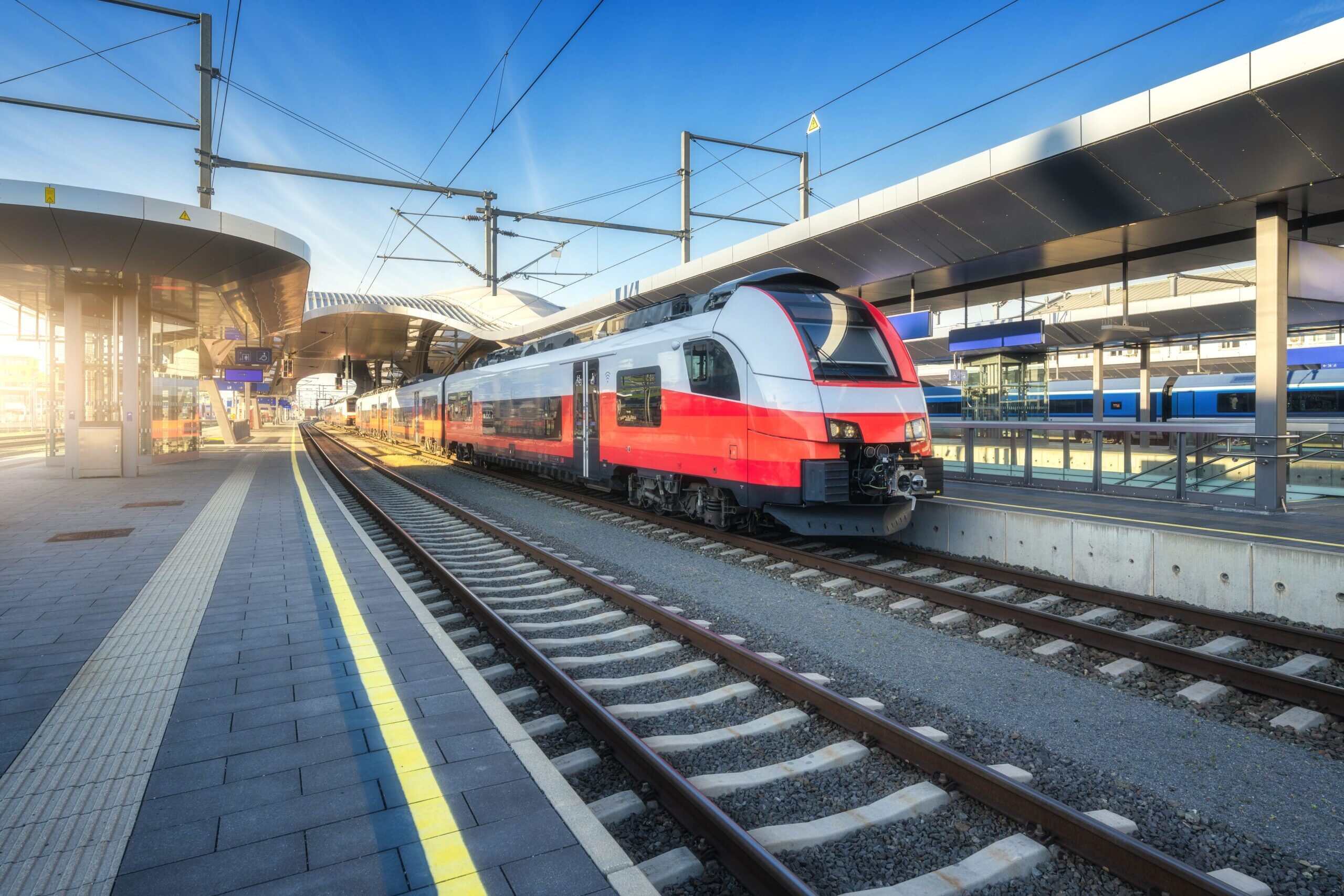 High-speed,Red,Passenger,Train,At,Railway,Station,Platform,Under,Clear Fahrzeugkommunikation und Verkehrsinfrastruktur im Mobility-&-Transportation-Umfeld
